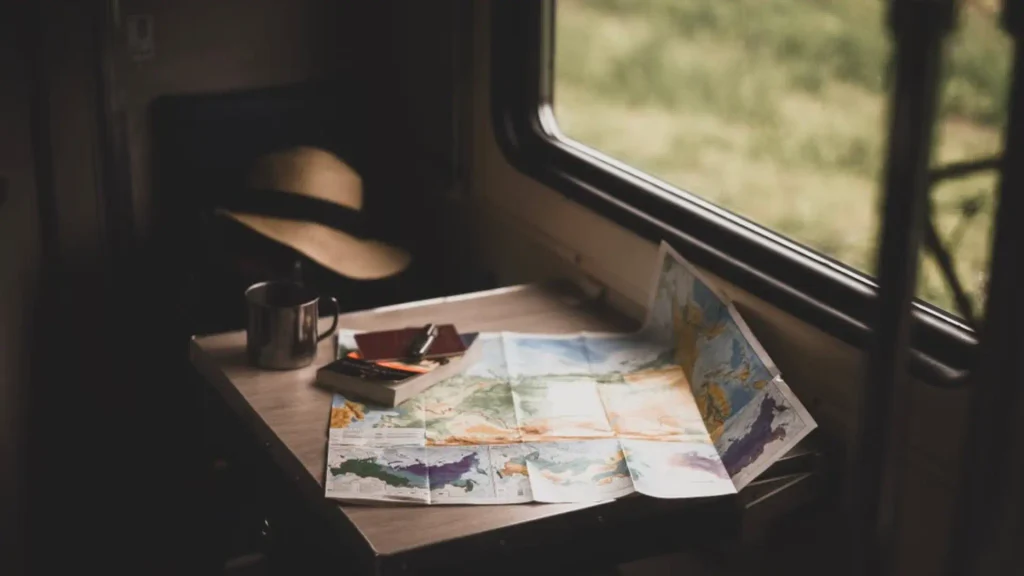 Passport, map and coffee mug on a train table while travelling