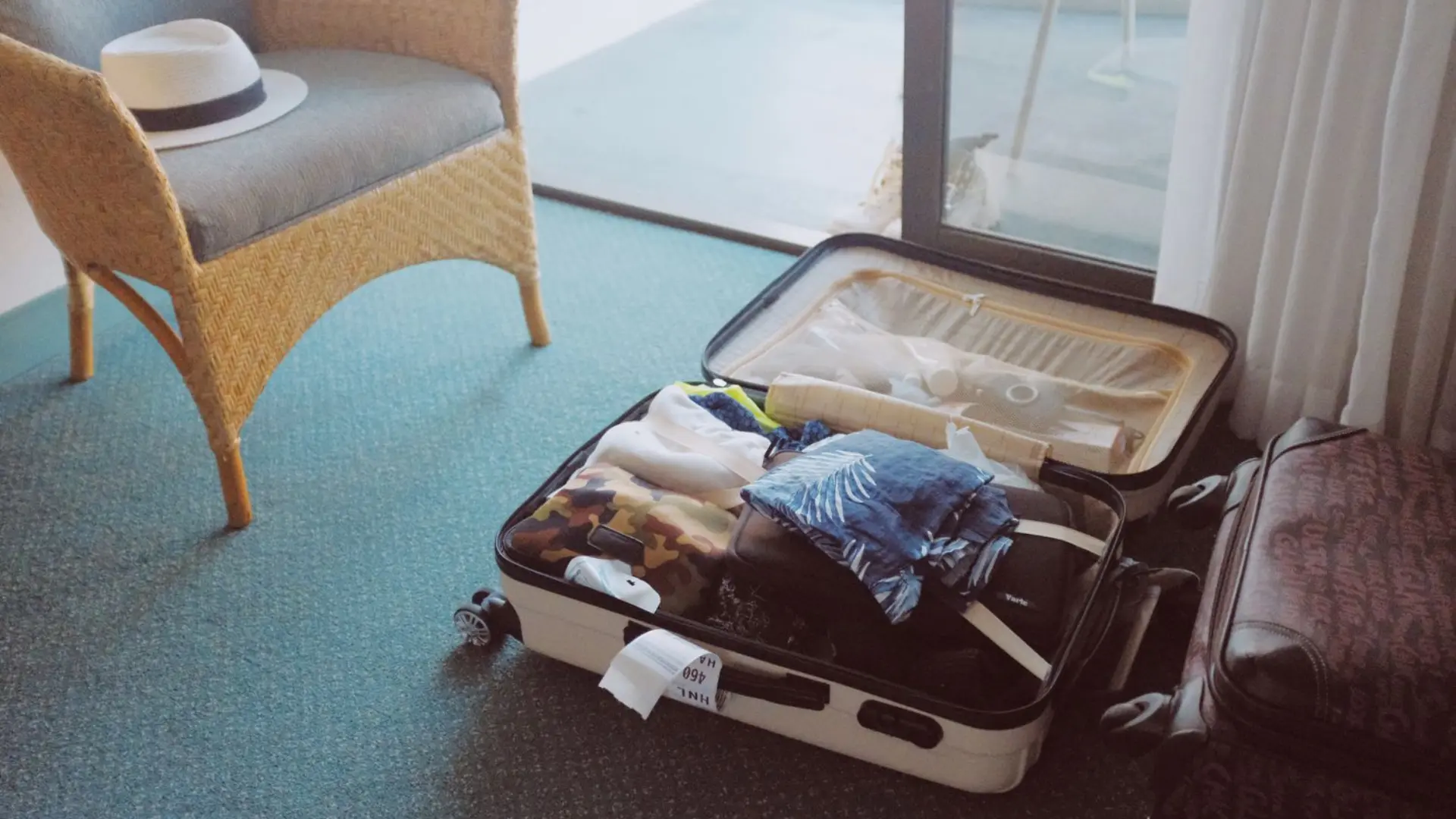 Half-packed suitcase on a hotel room floor, where negative thoughts before travelling often begin