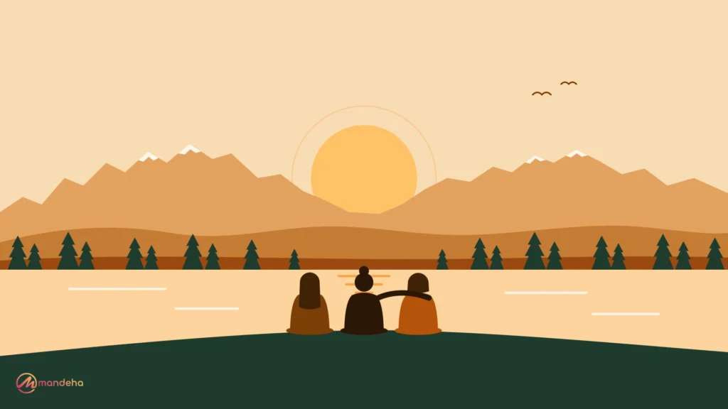 Three women sit together by a calm mountain lake at sunrise, a peaceful scene of a women’s retreat and shared mental wellness.