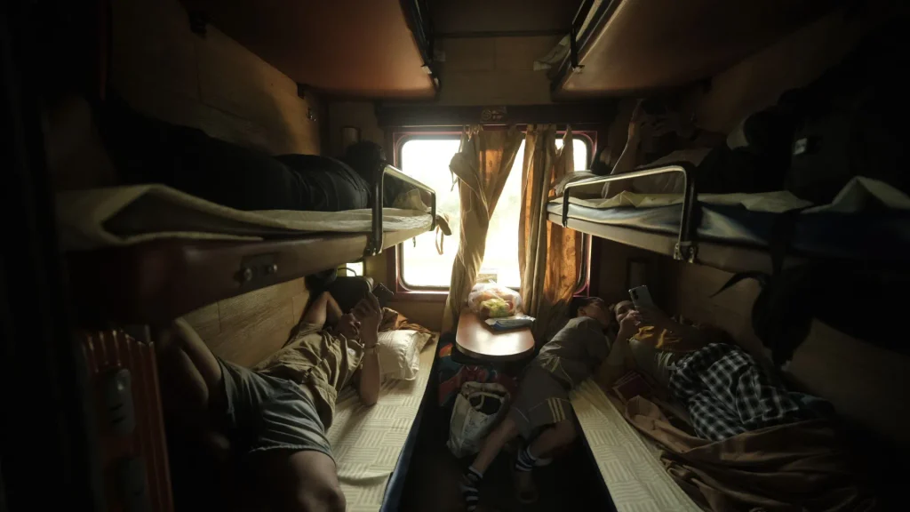 Traveller resting in an Indian train sleeper berth at night, sleeping in an unfamiliar place